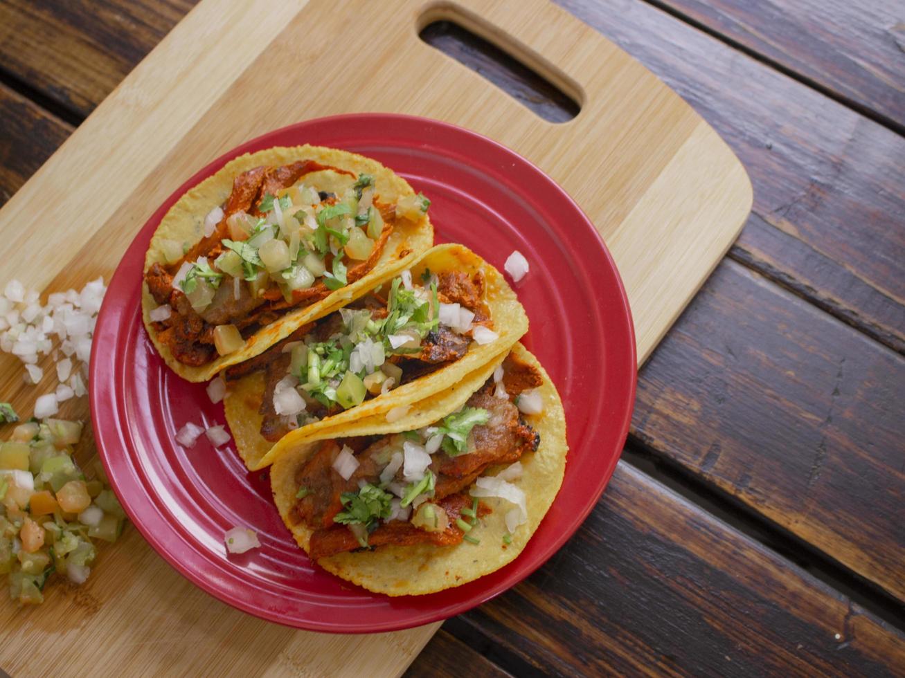 tacos de carne en una placa roja foto