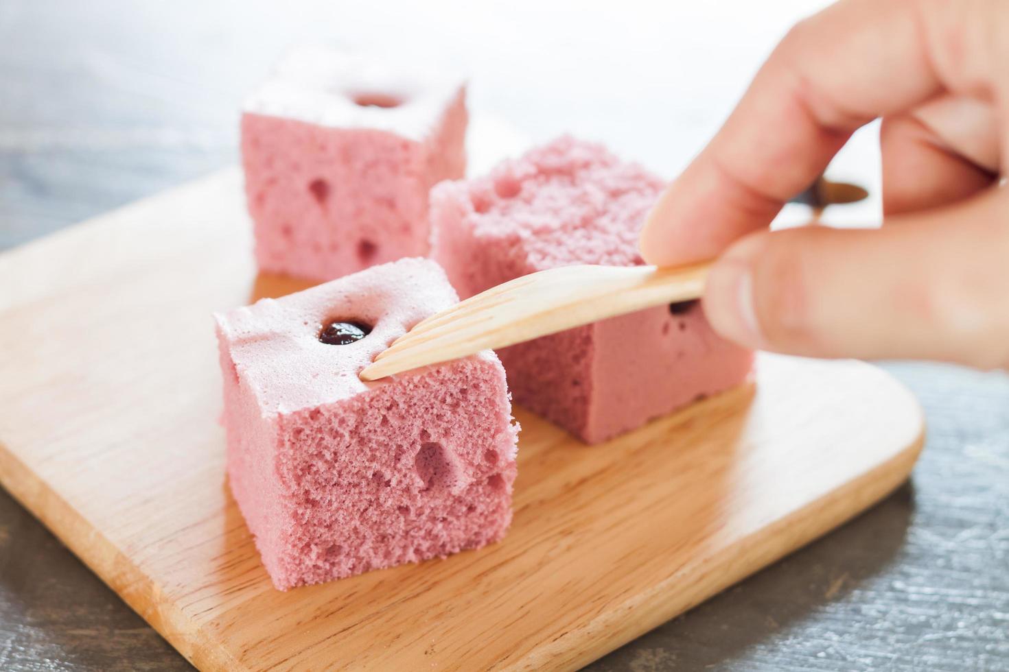 Pink cake squares on a wooden plate photo