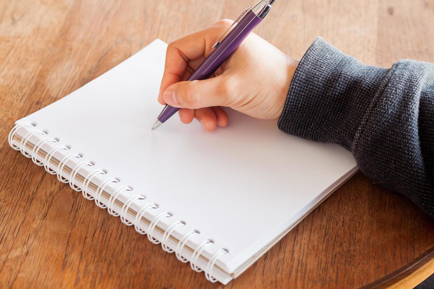 Close-up of a hand writing in a notebook photo