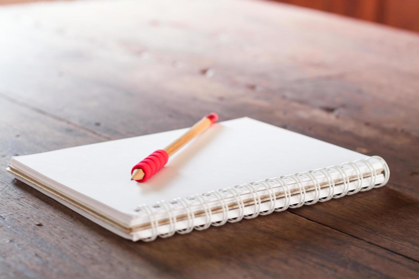 lápiz rojo en un cuaderno sobre una mesa foto