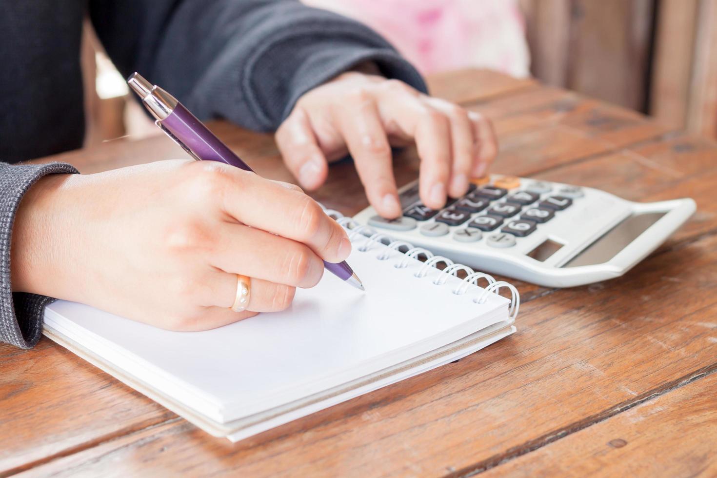 Person writing notes and making calculations photo