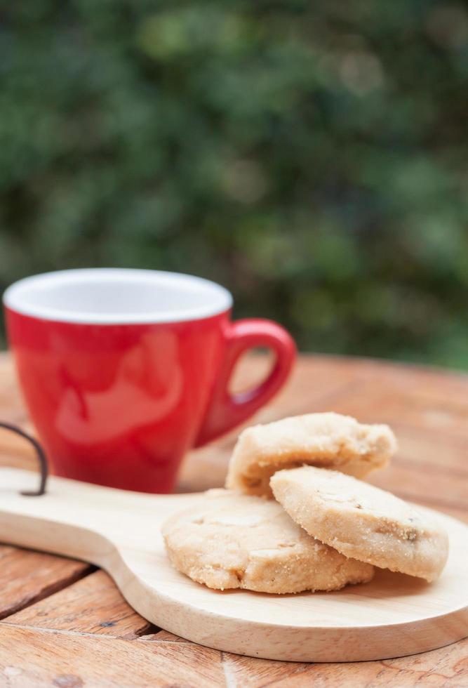 Galletas de anacardo en una bandeja de madera con una taza de café foto
