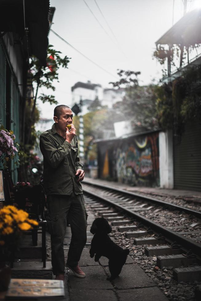 Man standing on train rail during daytime photo