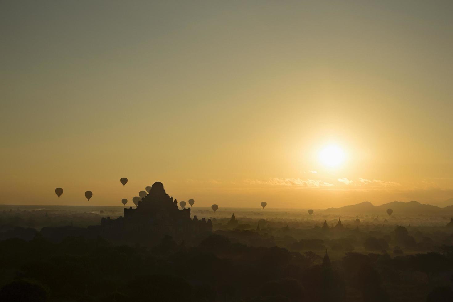 siluetas de globos de aire caliente al atardecer foto