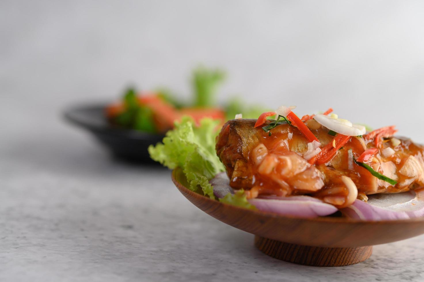 Spicy sardine salad in a wooden bowl photo