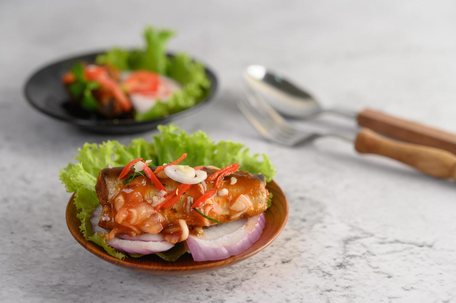 Spicy sardine salad in a wooden bowl photo