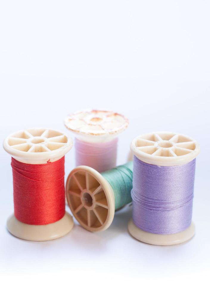 Colorful thread on spools on white background photo