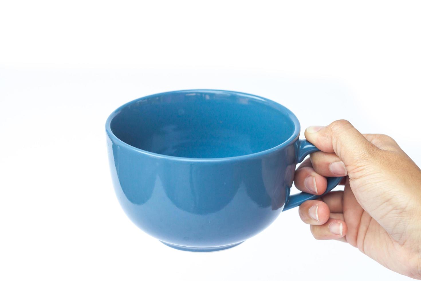 mano sosteniendo una taza azul foto