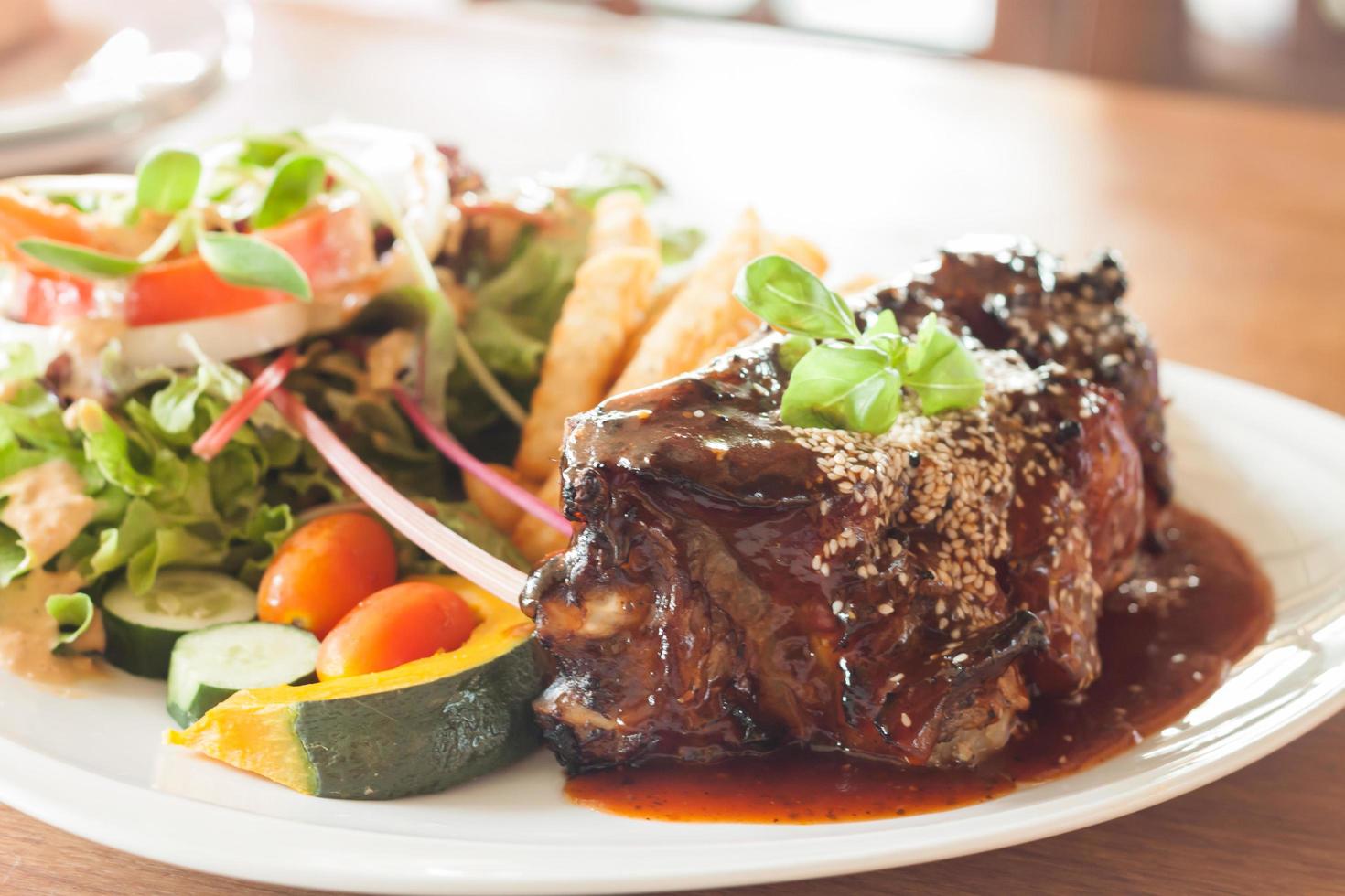 Pork ribs with spicy sauce and a salad photo