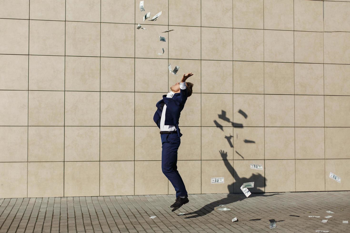 Young businessman throws around dollars photo
