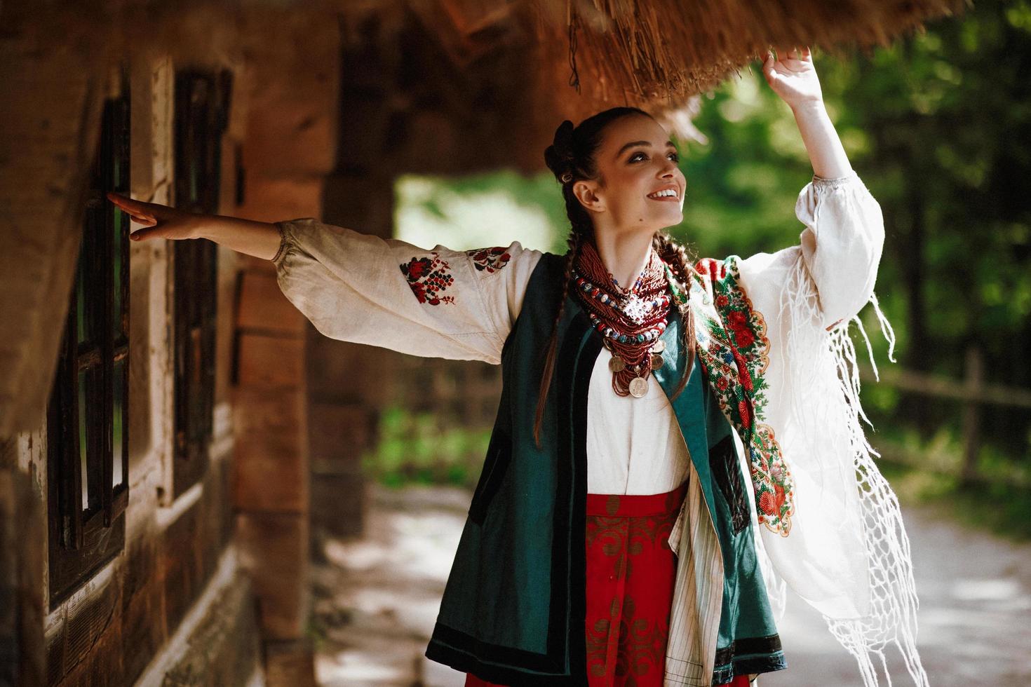 Young girl in a colorful Ukrainian dress dances and smiles photo