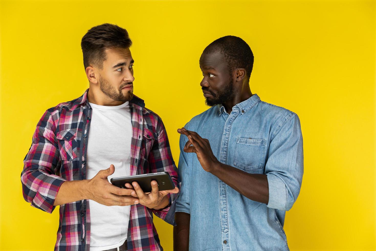 Two guys talking and holding a tablet photo