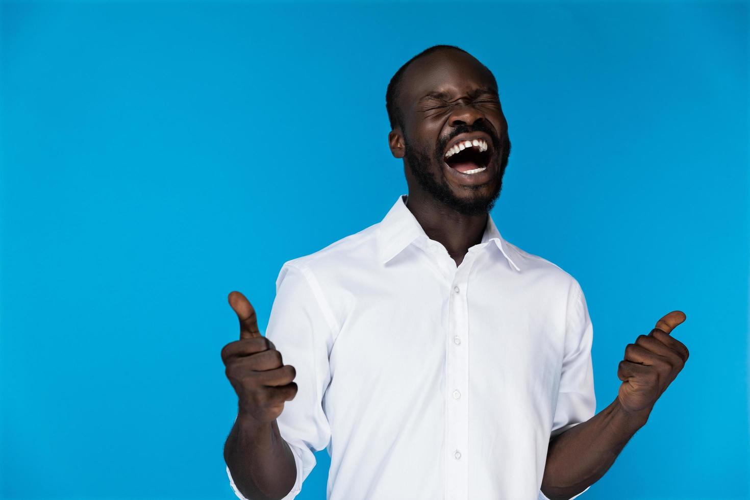 Man in white shirt holding two thumbs up photo