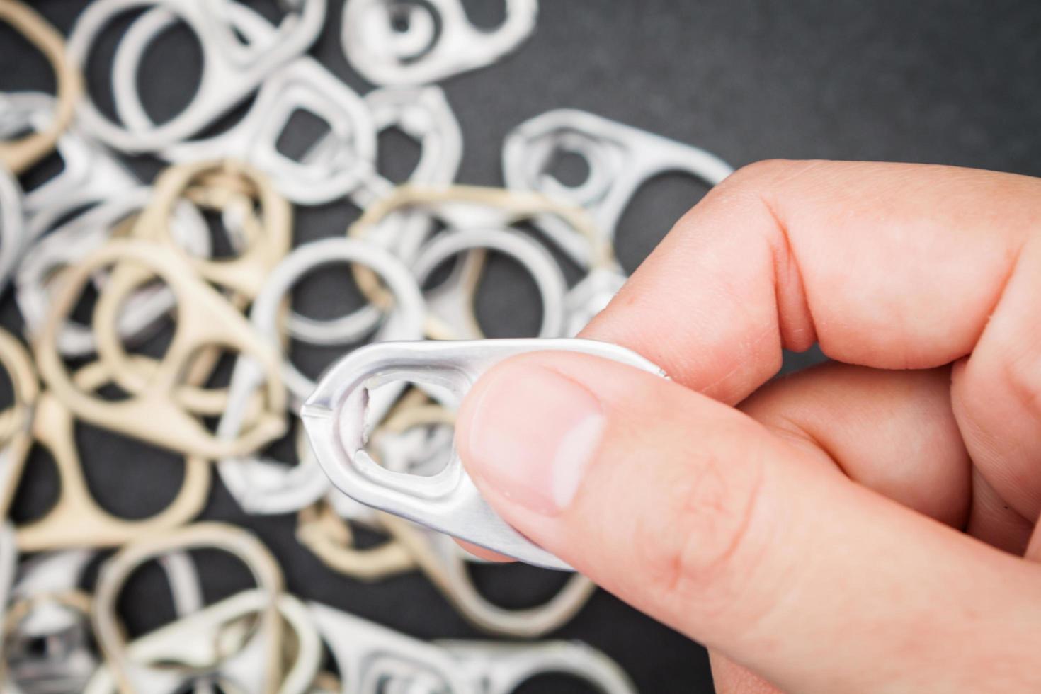 Hand holding a metal tab photo