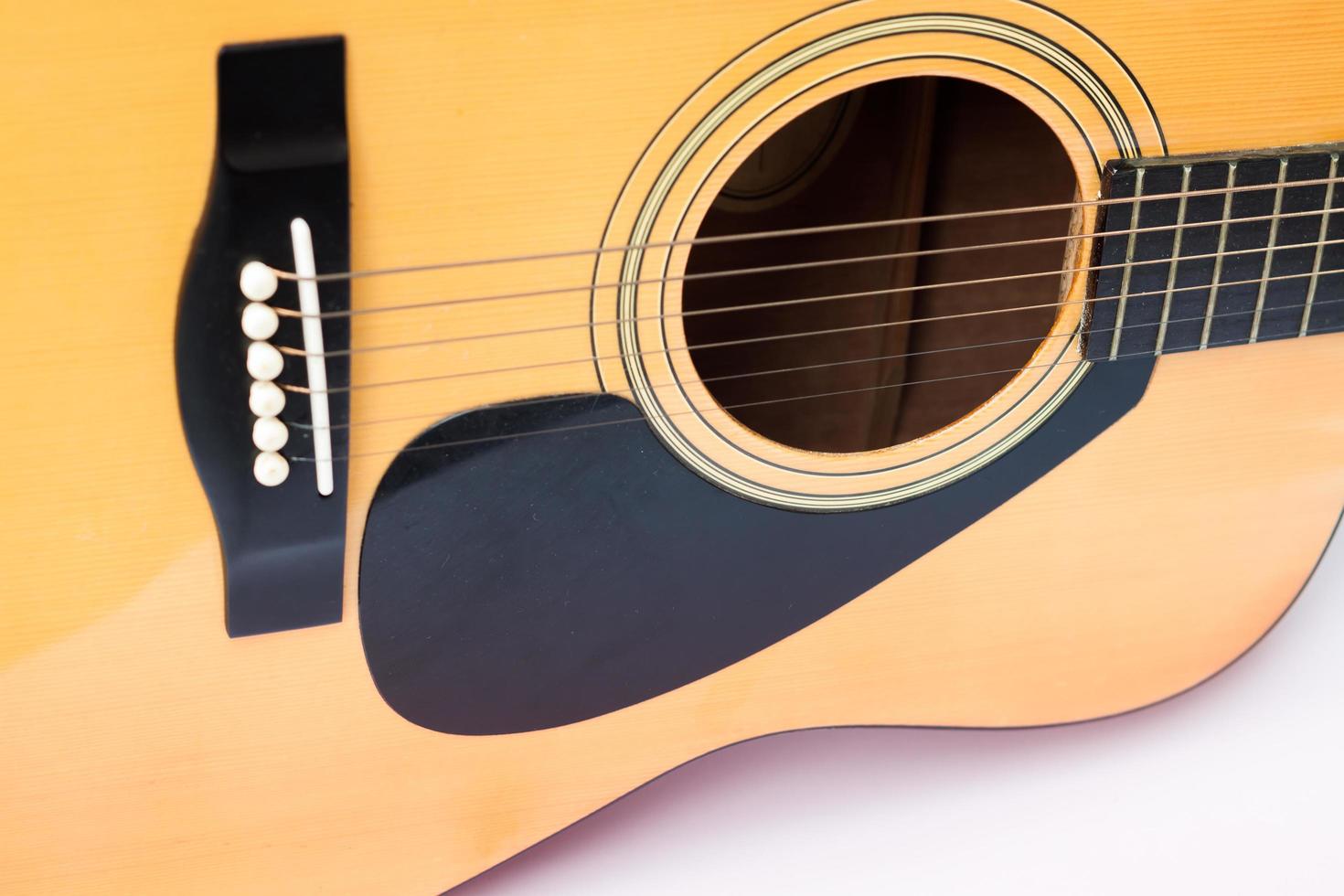 Close-up de una guitarra acústica sobre un fondo blanco. foto