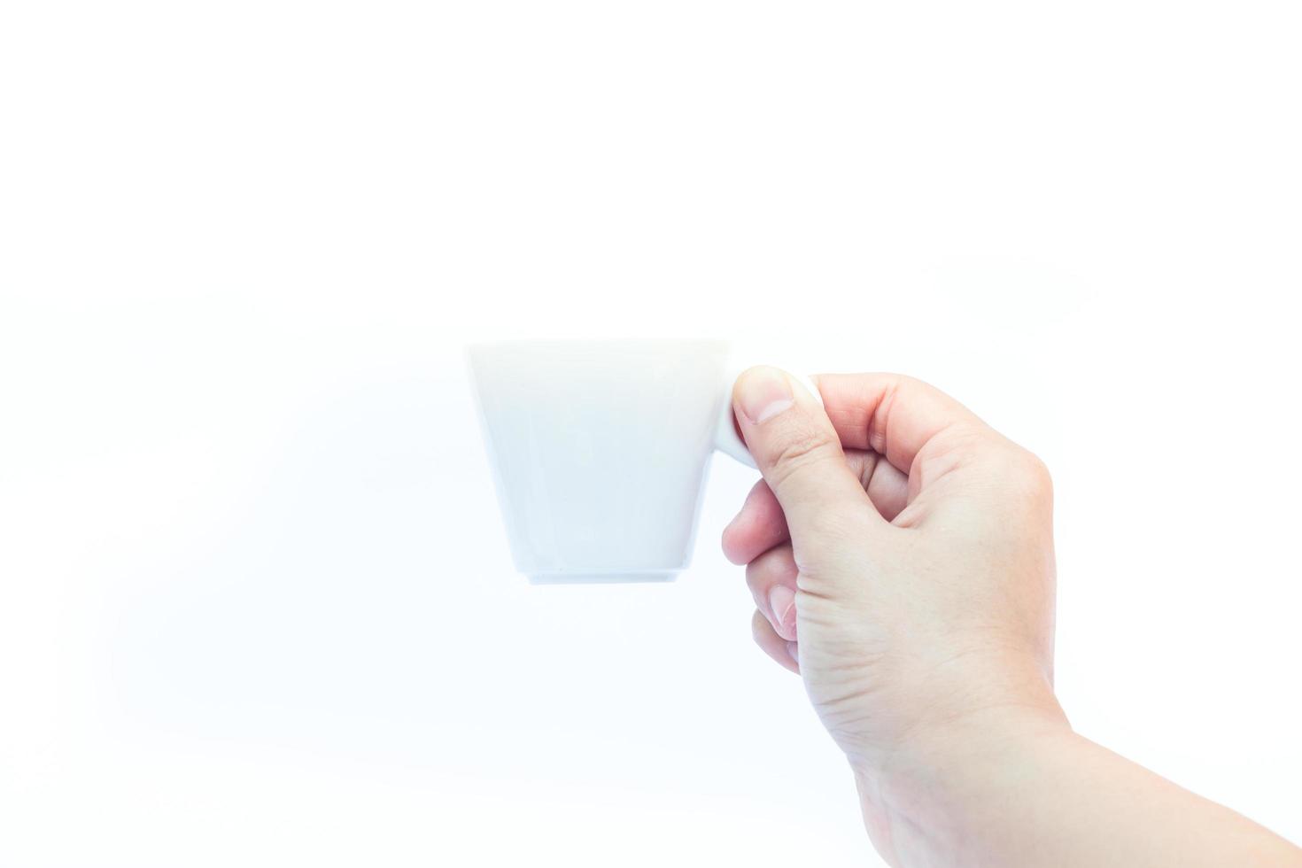 Hand holding a white espresso cup photo