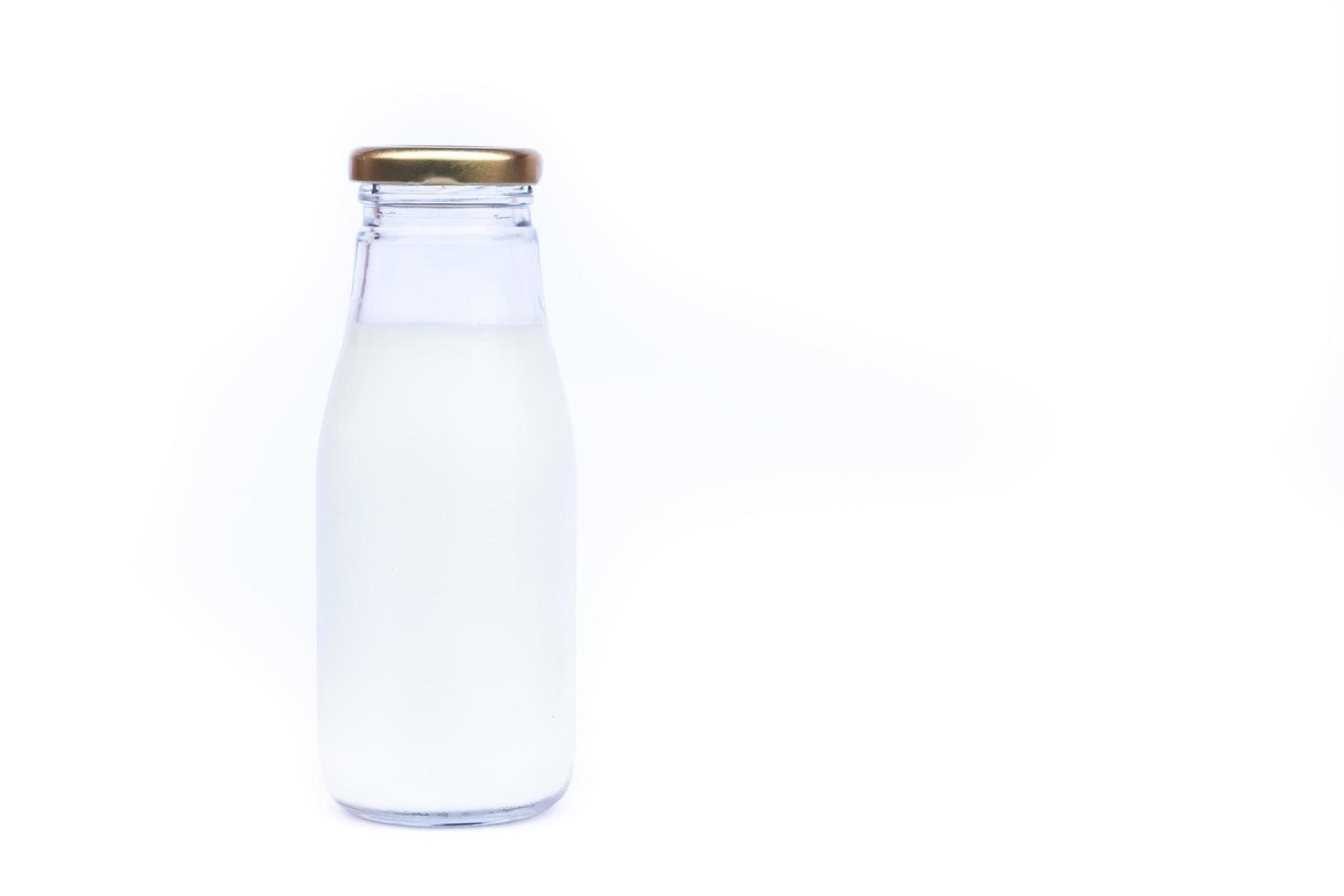 Botella de leche de vidrio sobre fondo blanco con espacio de copia foto