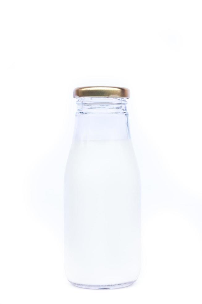 Botella de leche de vidrio sobre un fondo blanco. foto