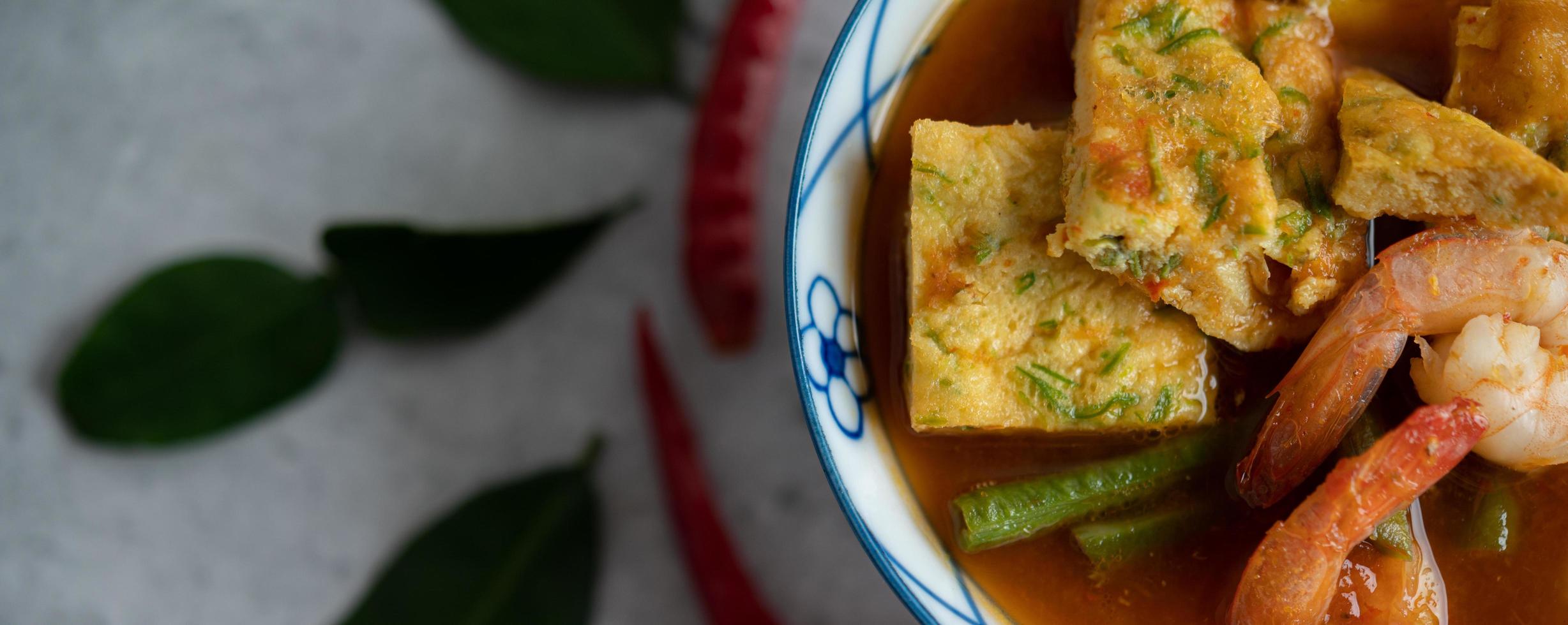 Hot and sour soup with cha-om, egg, and shrimp photo