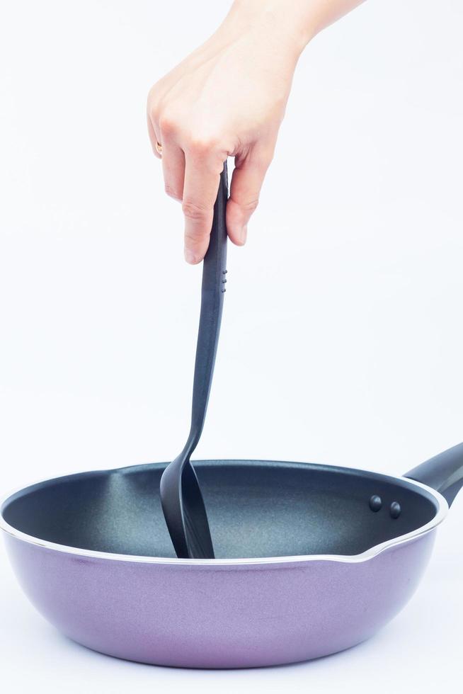 Person holding a spatula in a pan photo
