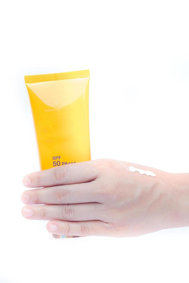 Hand holding a bottle of sunscreen photo