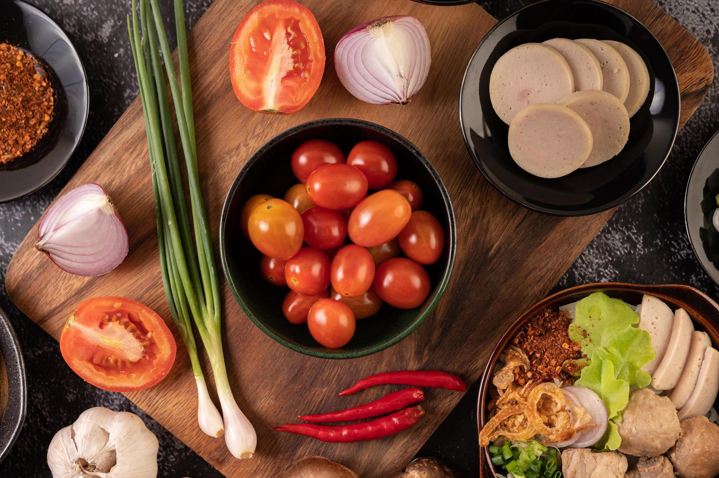 Red cherry tomatoes with spring onions, peppers, tomatoes, and red onions photo