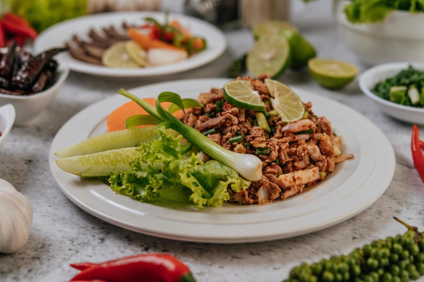 plato de larb de cerdo con ingredientes foto