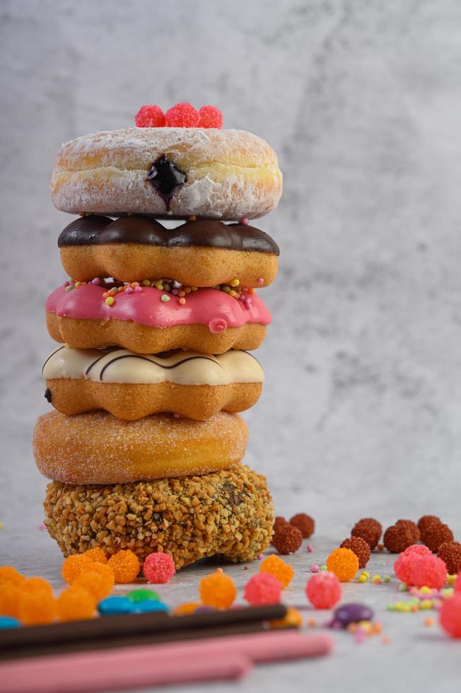 A stack of assorted donuts and toppings photo