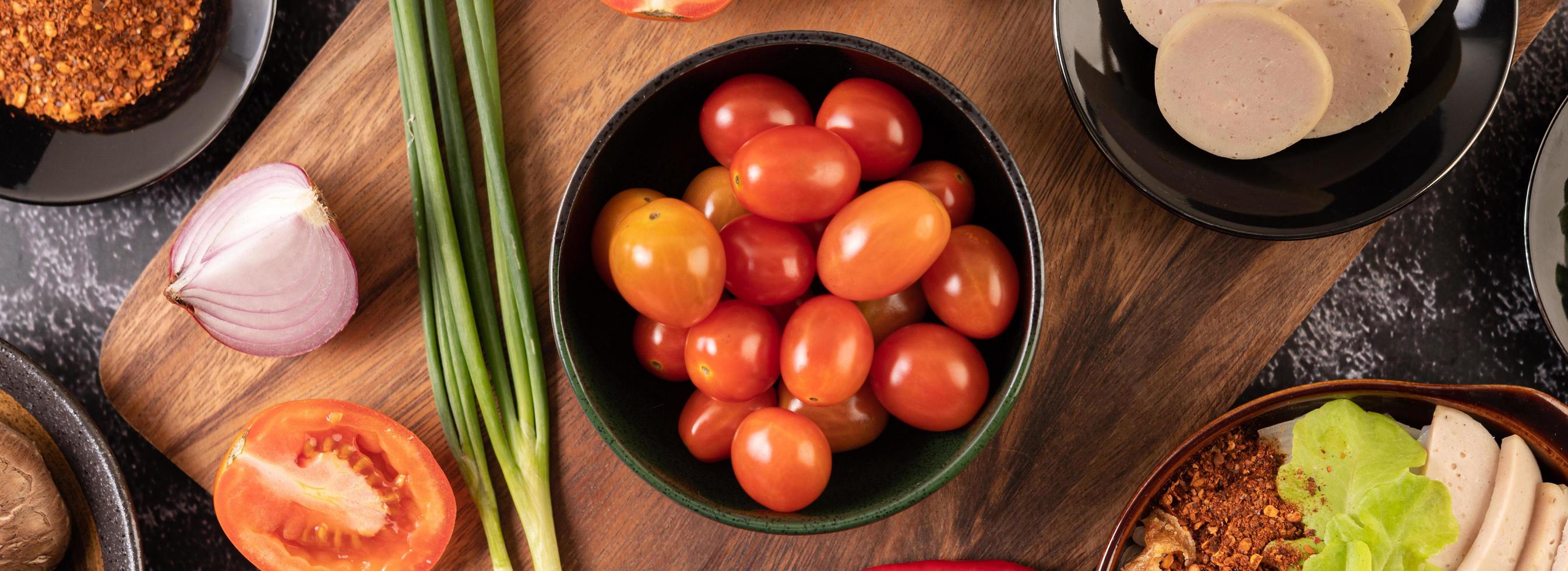 Red cherry tomatoes with spring onions, peppers, tomatoes, and red onions photo