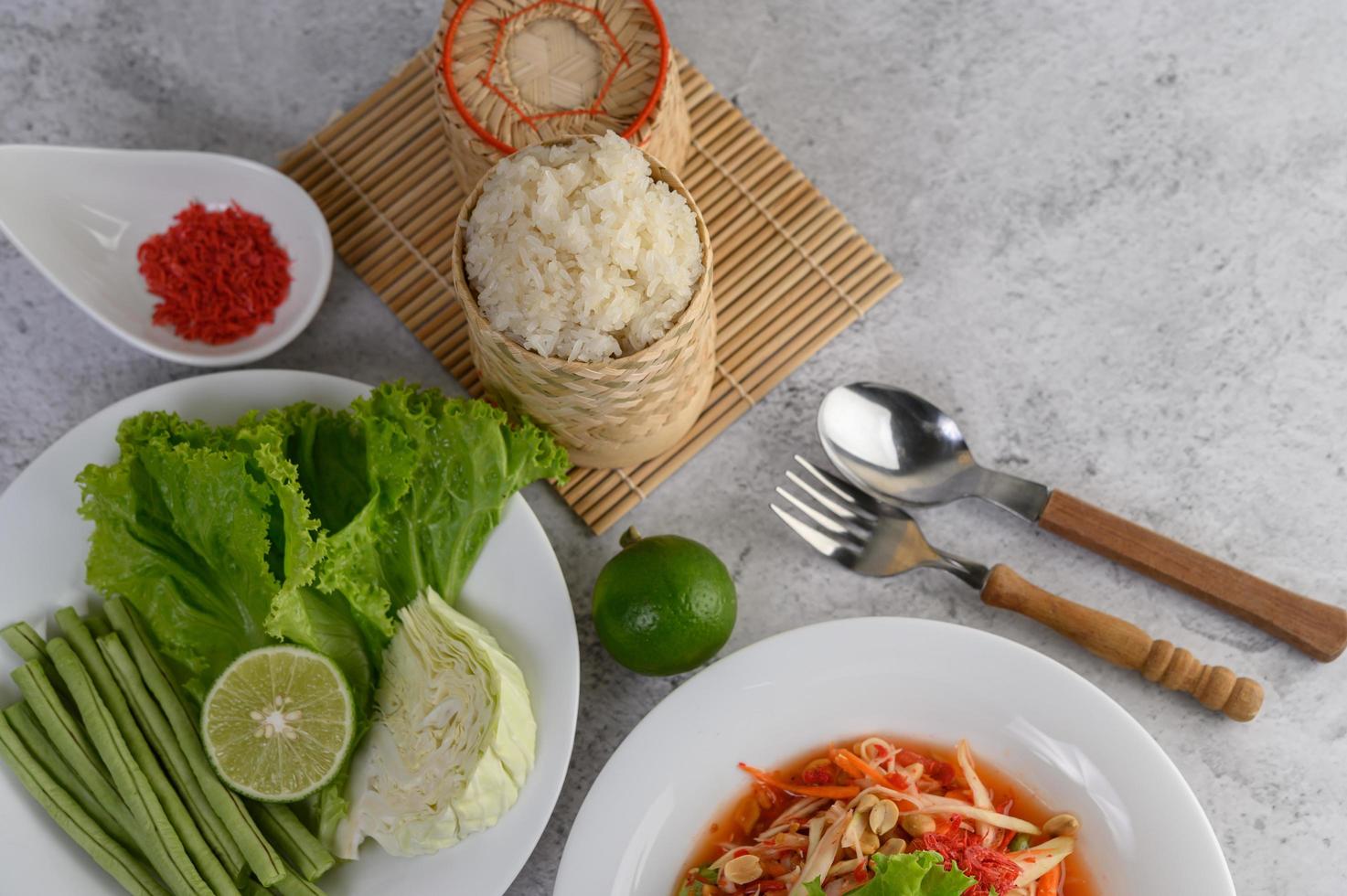 Thai papaya salad with sticky rice, lime and chili photo