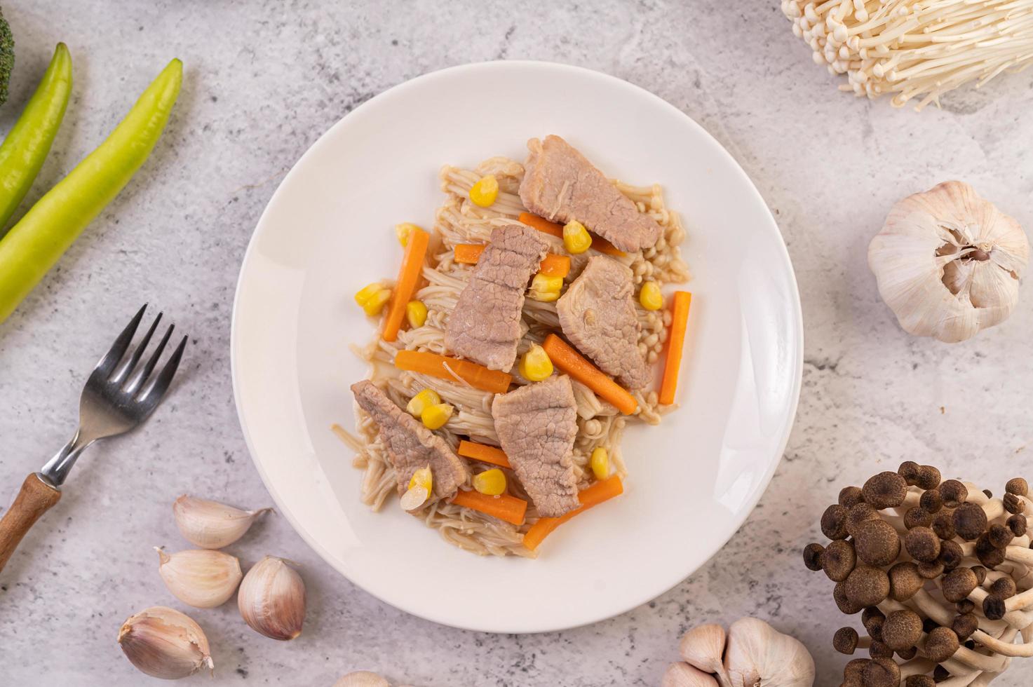 plato de cerdo con zanahorias y maíz foto