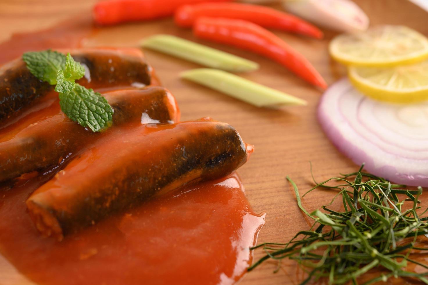 Sardinas en salsa de tomate en bandeja de madera foto