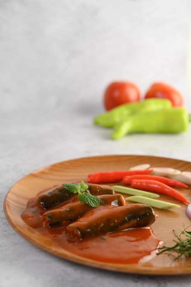 Sardines in tomato sauce on a wooden tray photo