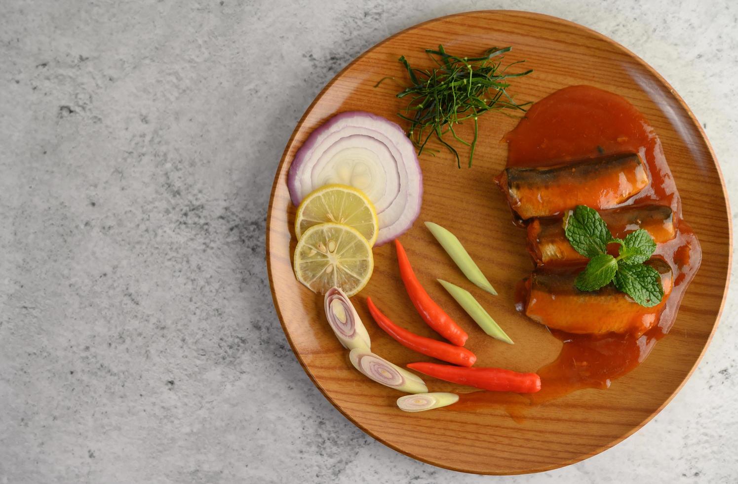 Spicy sardine salad on a wooden plate photo