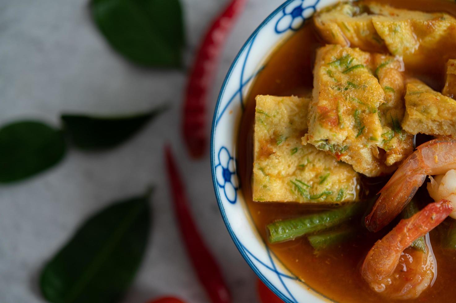 Hot and sour soup with cha-om, egg, and shrimp photo