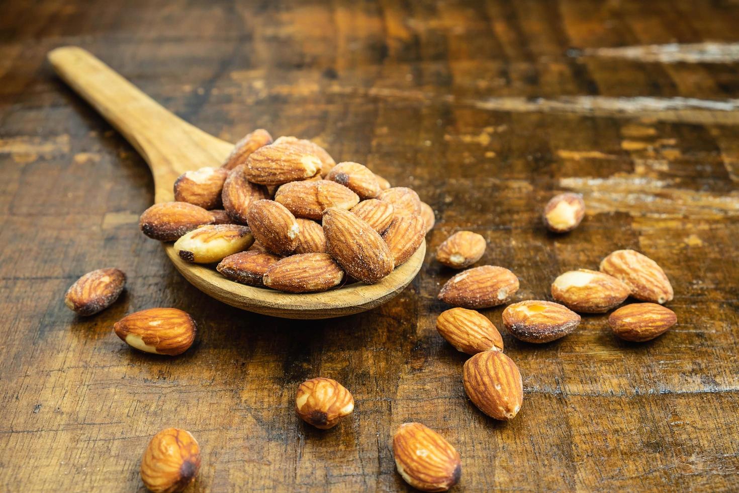 Wooden spoon with almonds on it photo