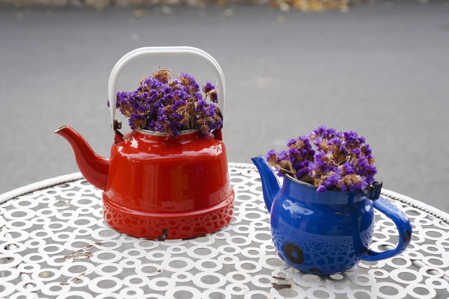 Vintage teapots with purple dry flowers photo