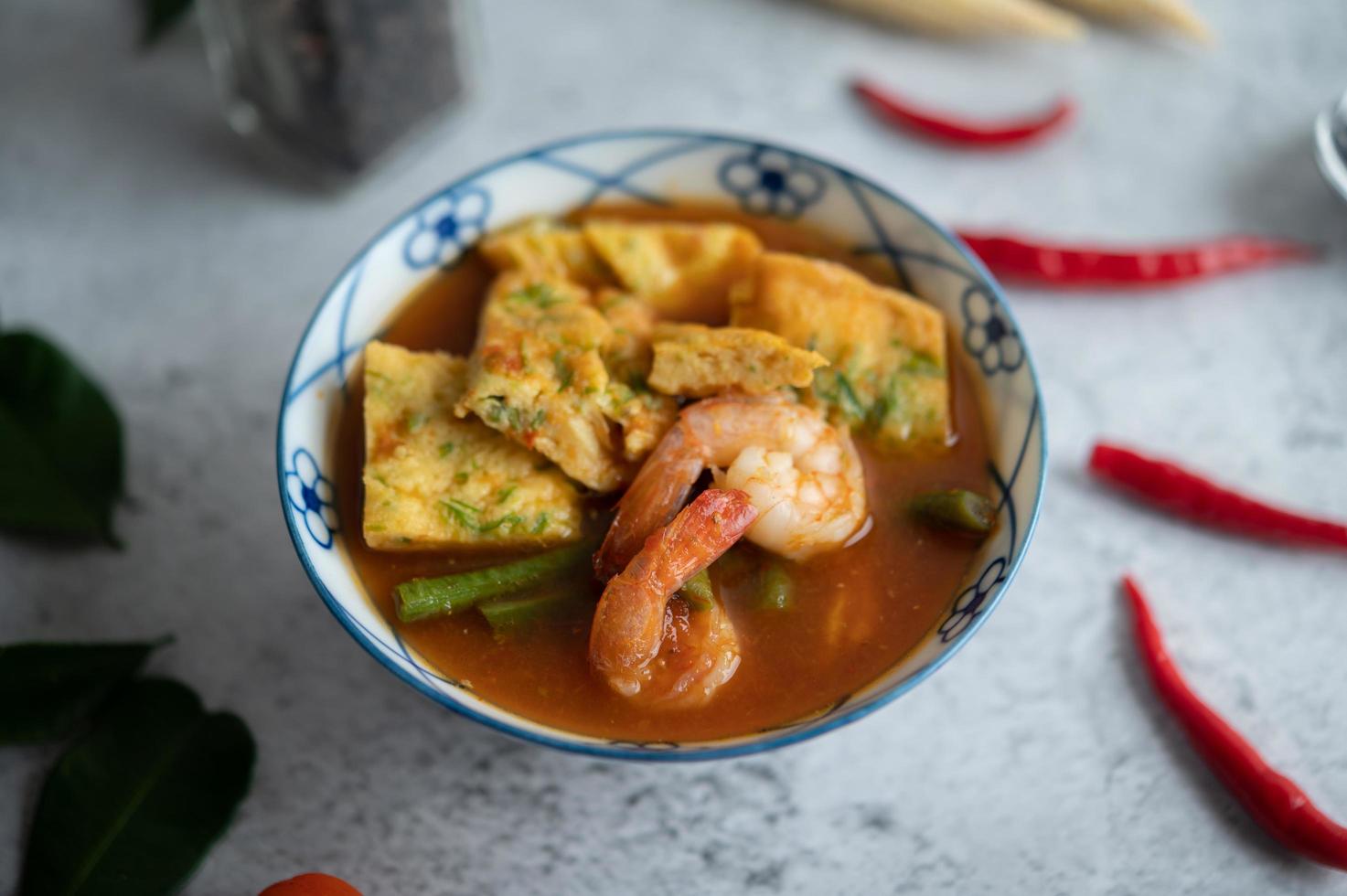 Hot and sour soup with cha-om, egg, and shrimp photo