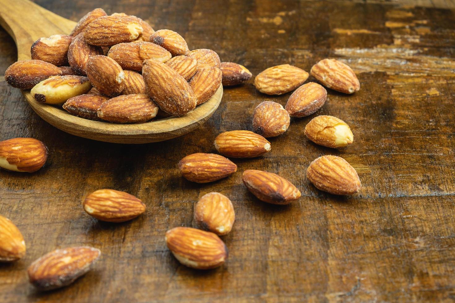 almendras en una cuchara de madera foto