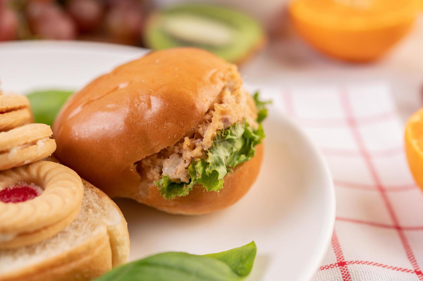 Bread slices with cookies and vegetables and a burger photo