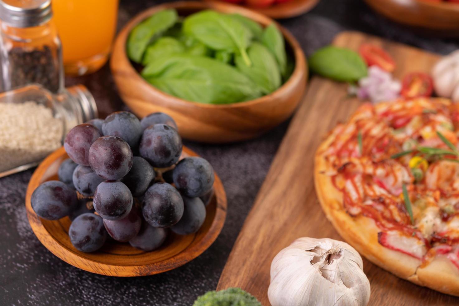 Black grapes with tomatoes orange juice and pizza photo