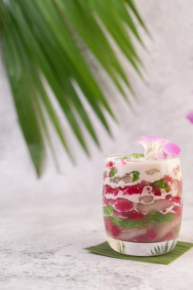 postre en un vaso sobre una hoja de plátano foto