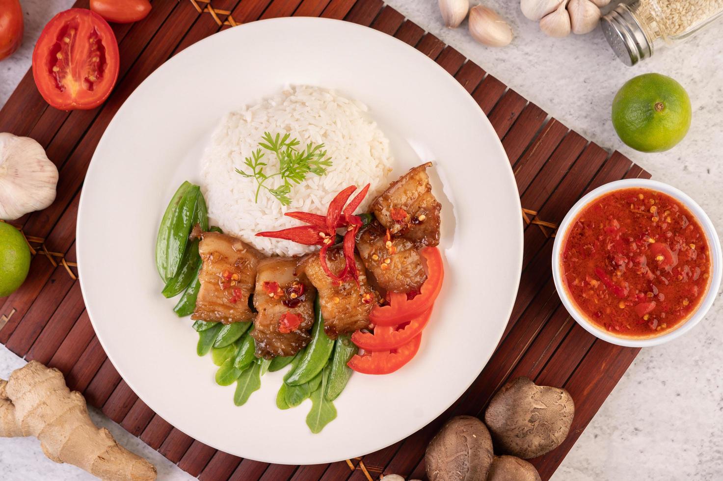 Pork belly on streamed rice with vegetables photo