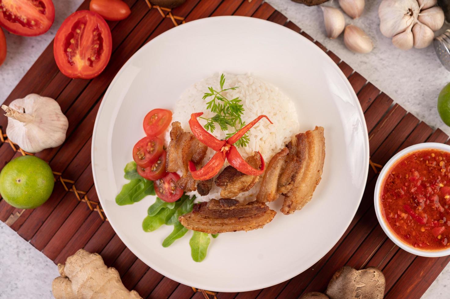 Pork belly on streamed rice with vegetables photo