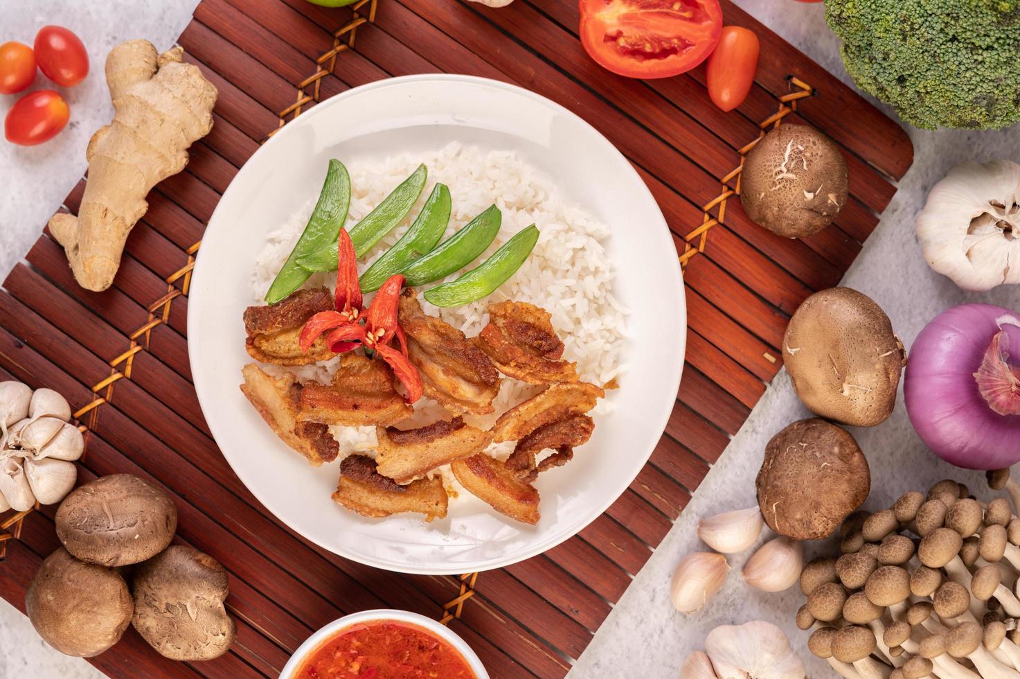 Pork belly on streamed rice with vegetables photo