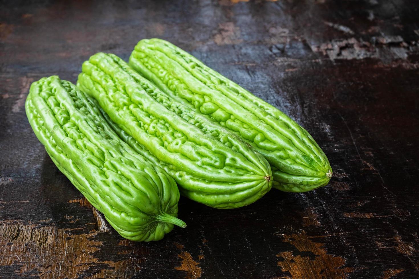 Calabazas verdes sobre una mesa de madera oscura. foto