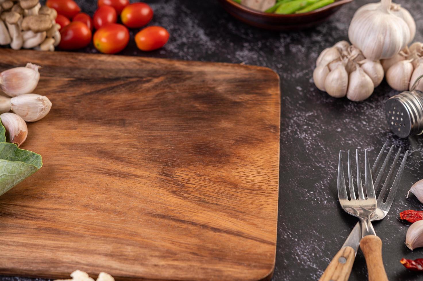 Garlic, tomato and a cutting board photo