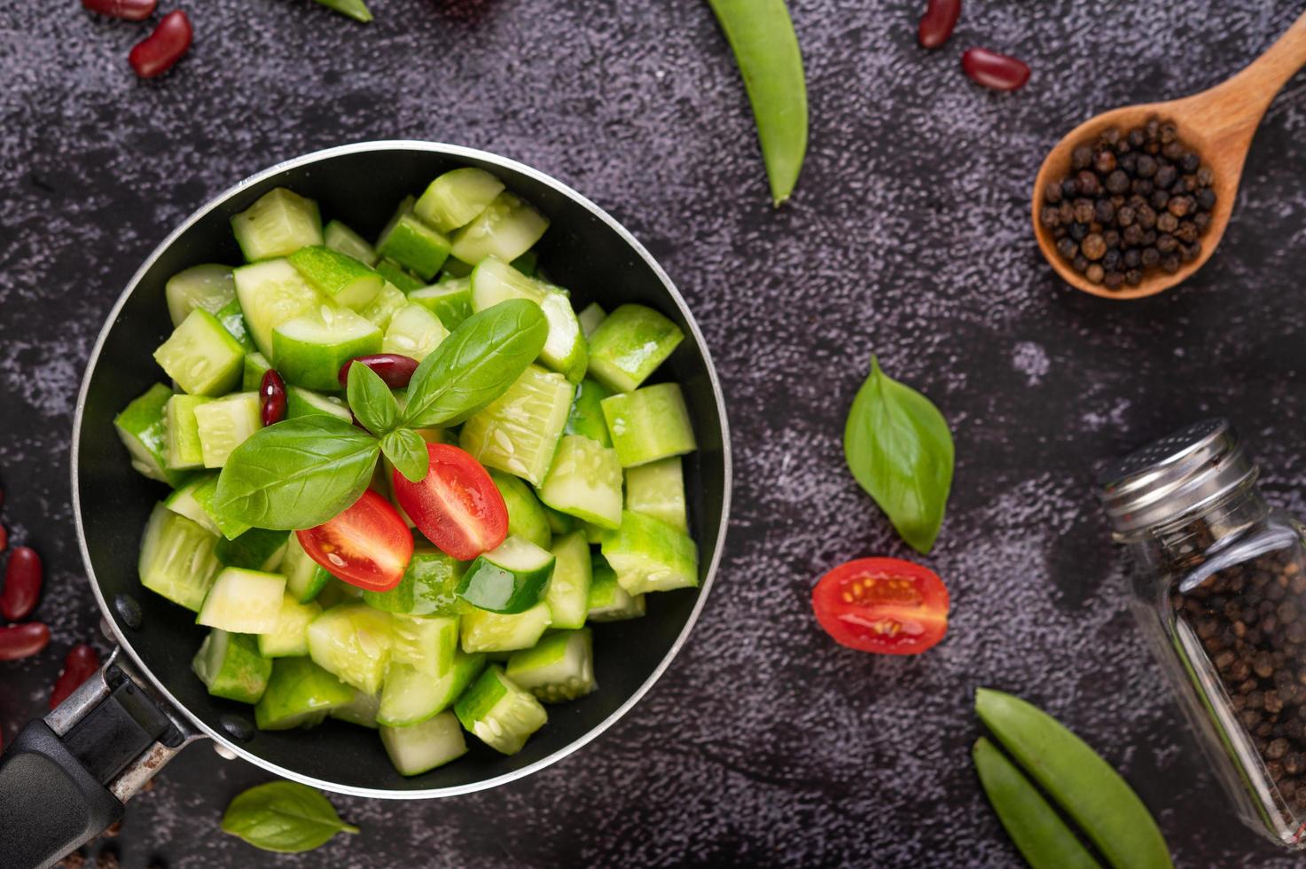 Cucumbers with tomatoes in a frying pan photo