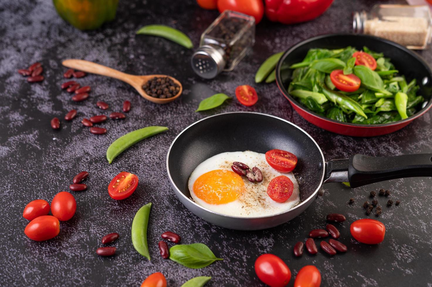 Fried eggs in a frying pan with tomatoes photo