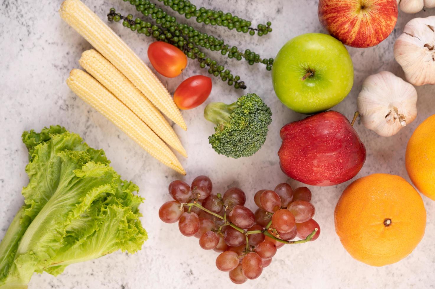 Top view of apples, oranges, broccoli, baby corn, grapes and tomatoes photo